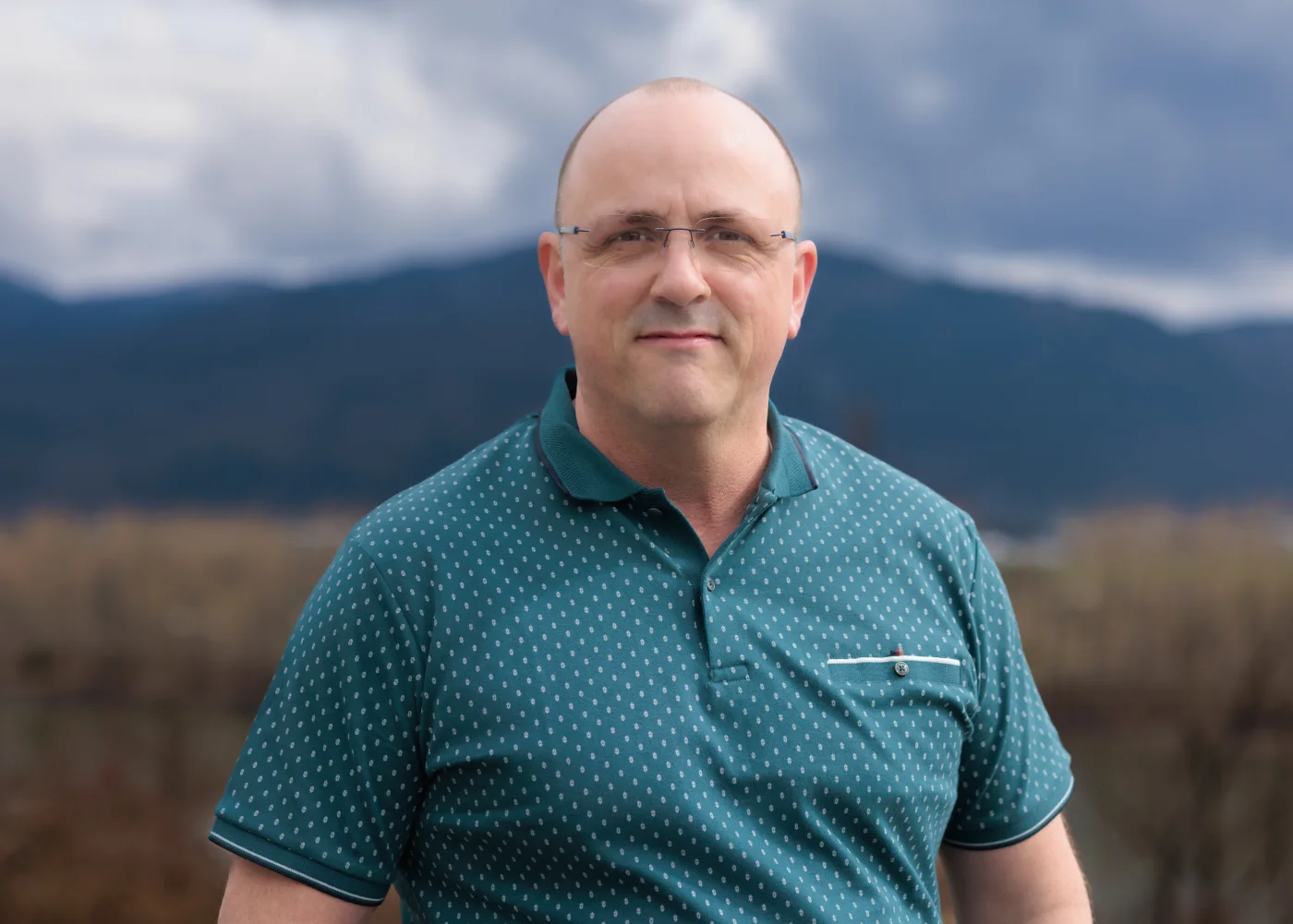 Trace Hobson outdoors with mountains behind him